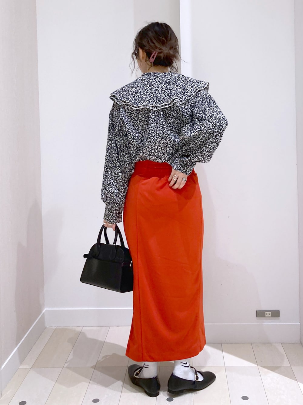 ブラック系のショルダーバッグ、ブラック系のシャツ/ブラウス、レッド系のスカートを着用したレディースの春コーディネートの3枚目の写真