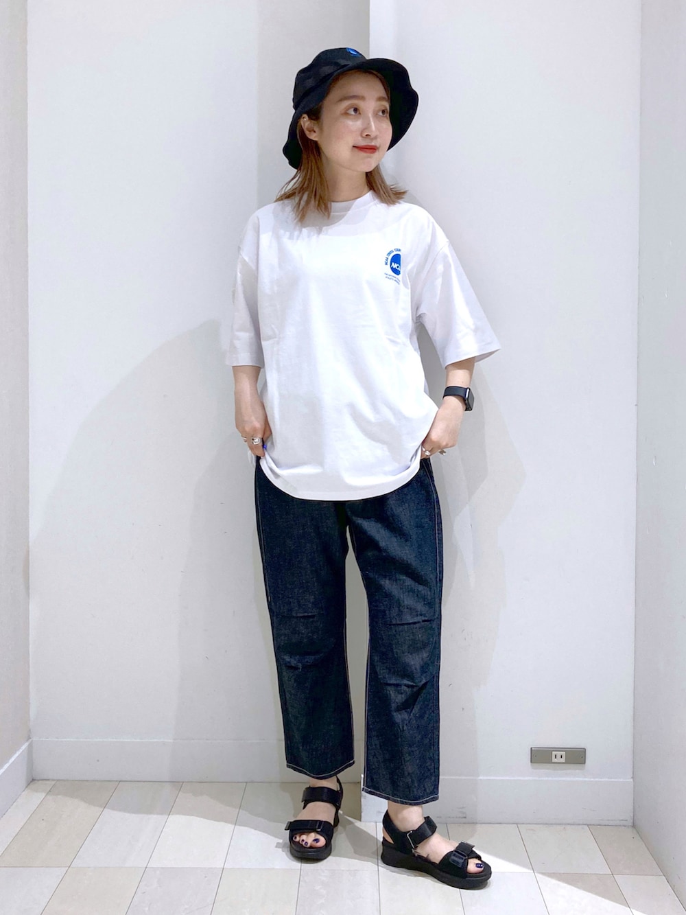 ブルー系のデニムパンツ、その他のサンダル、ベージュ系のショルダーバッグを着用したレディースの夏コーディネートの2枚目の写真