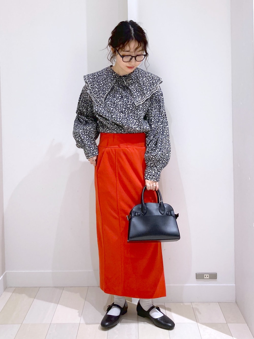 ブラック系のショルダーバッグ、ブラック系のシャツ/ブラウス、レッド系のスカートを着用したレディースの春コーディネートの4枚目の写真