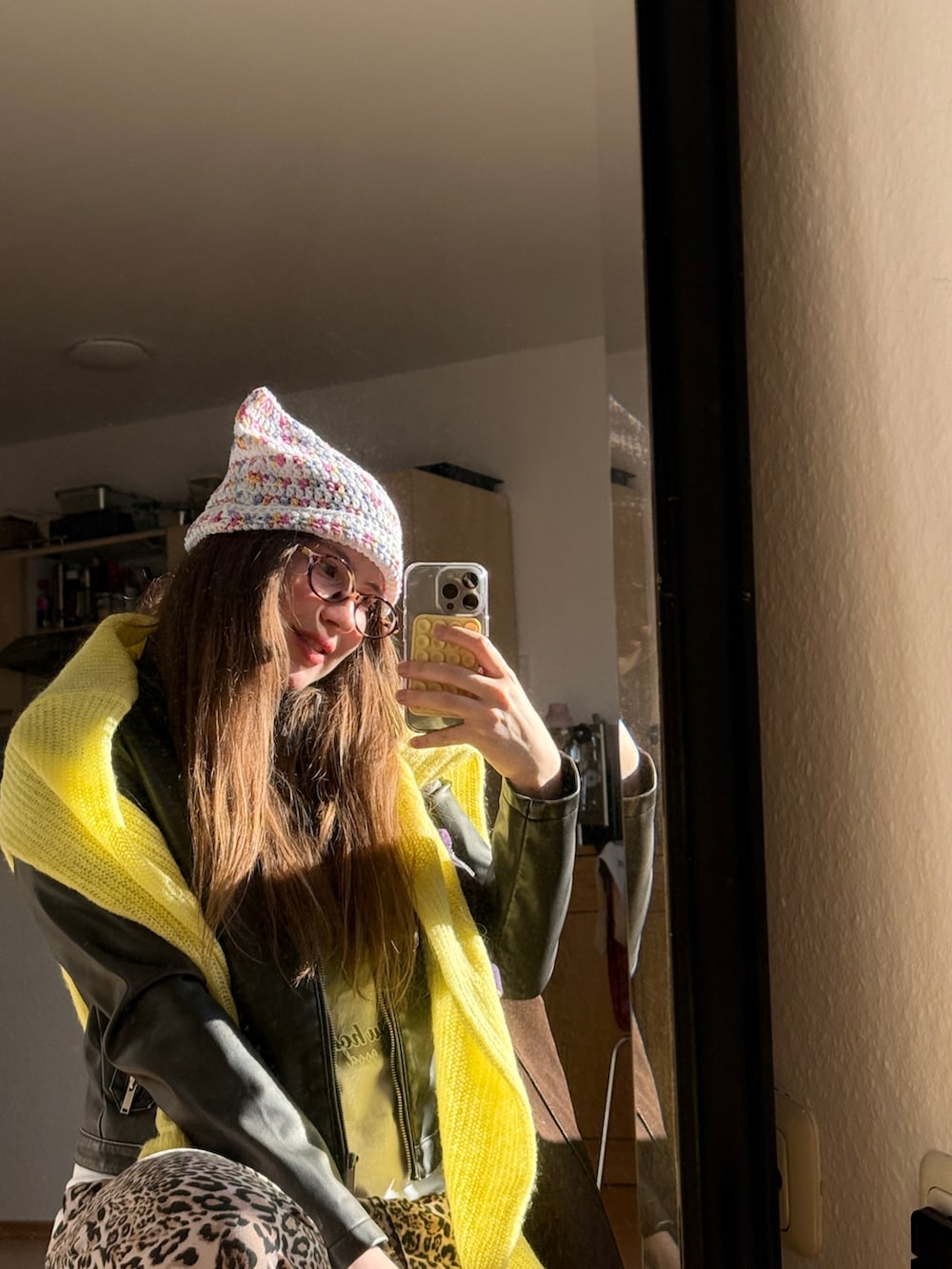 イエロー系のニット/セーター、ブラック系のジャケット/アウター、ブラウン系のトートバッグを着用したレディースの春コーディネートの2枚目の写真