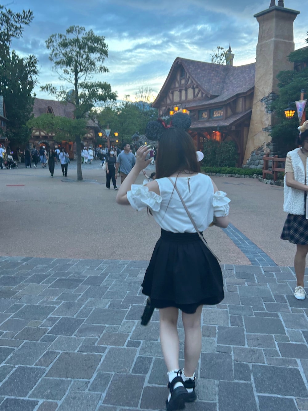 ホワイト系のトップス、ブラック系のスカート、ピンク系のバッグを着用したレディースの秋コーディネートの3枚目の写真