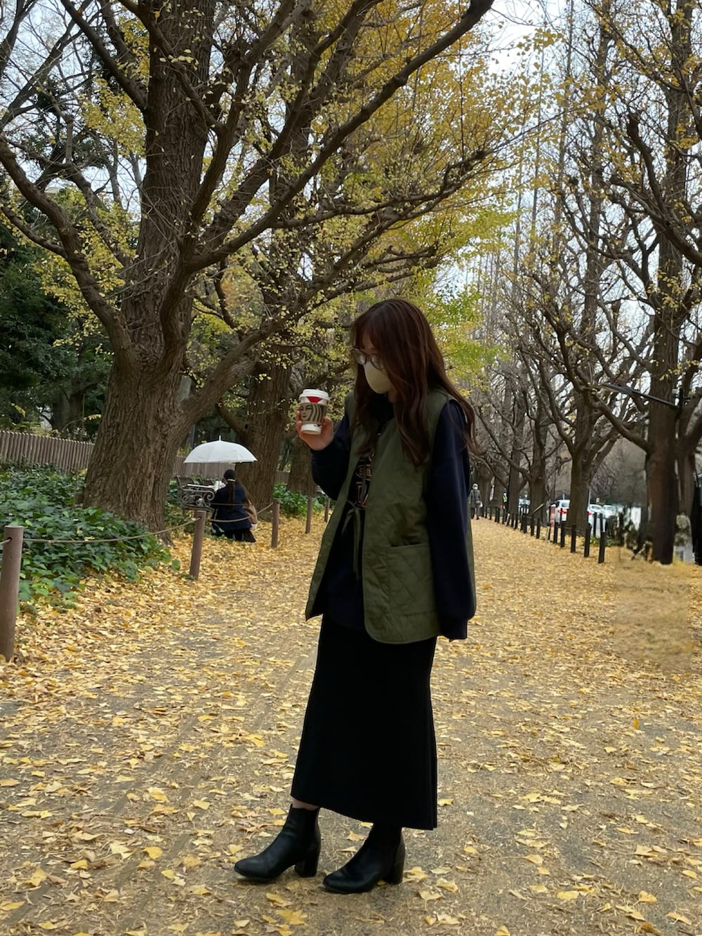 ブラック系のブーツ、ブラック系のスカート、その他のトップスを着用したレディースの冬コーディネートの2枚目の写真