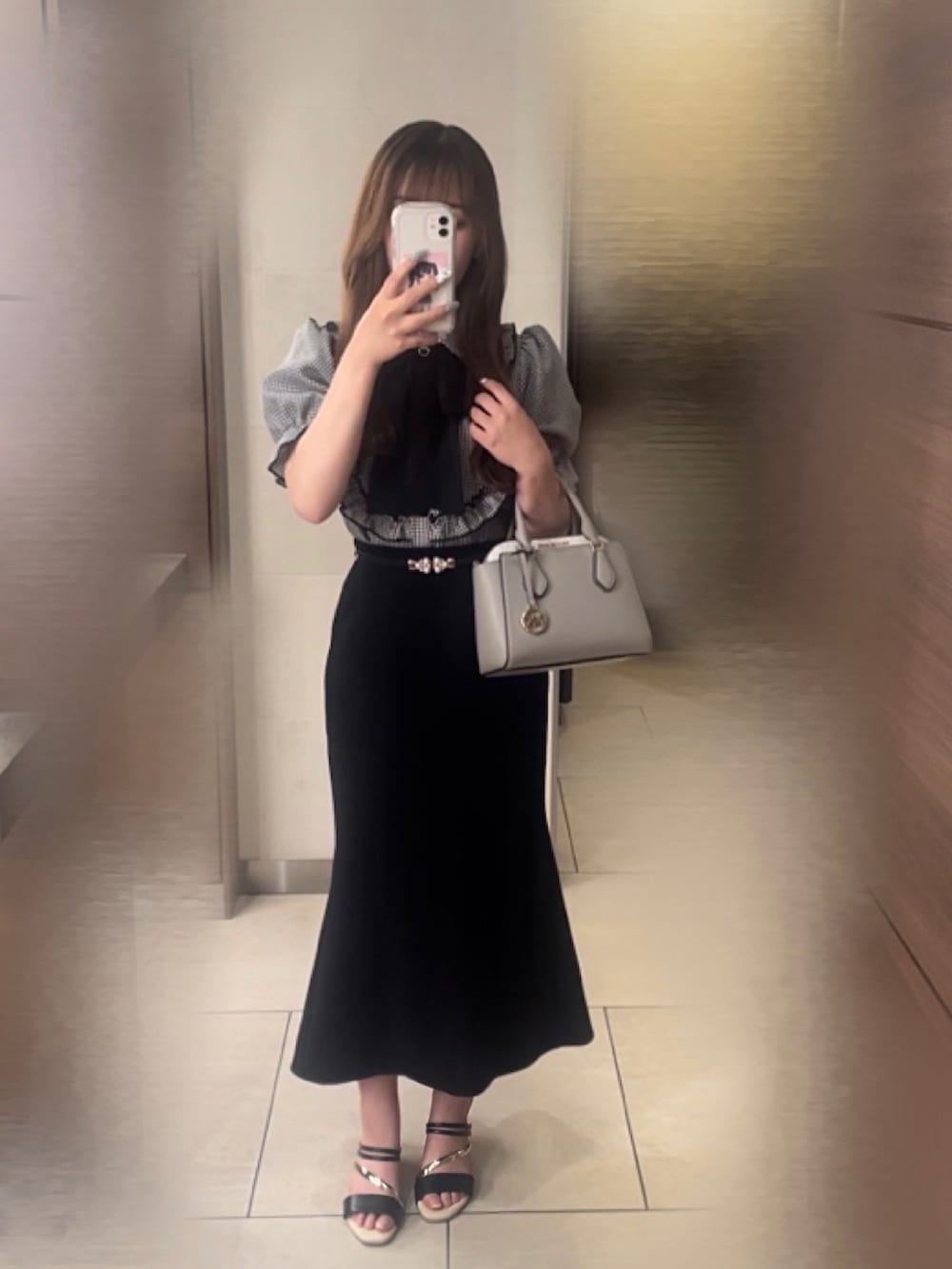 ブラック系のスカート、ブラック系のトップス、ブラック系のサンダルを着用したレディースの秋コーディネートの3枚目の写真