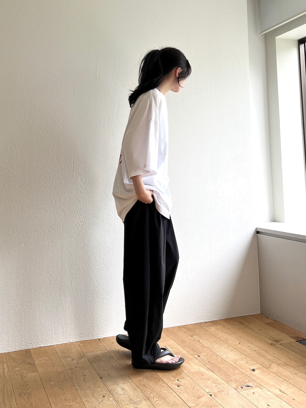ホワイト系のTシャツ/カットソー、ブラック系のその他パンツ、ブラック系のサンダルを着用したレディースの夏コーディネートの2枚目の写真