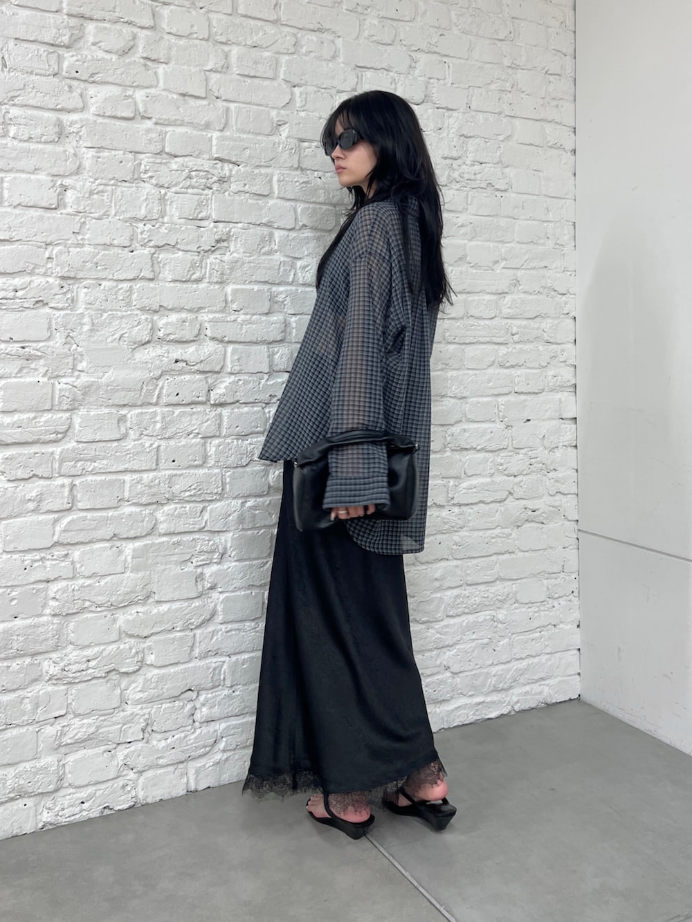 グレー系のシャツ/ブラウス、ブラック系のスカート、ブラック系のショルダーバッグを着用したレディースの夏コーディネートの3枚目の写真