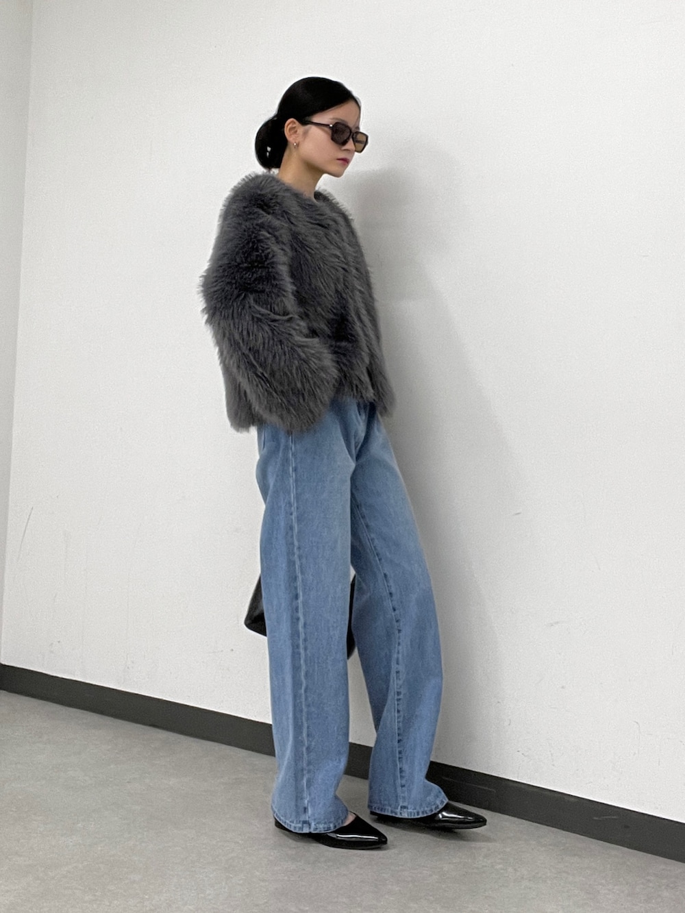 ブルー系のデニムパンツ、グレー系のその他アウター、ブラック系のトートバッグを着用したレディースの秋コーディネートの2枚目の写真