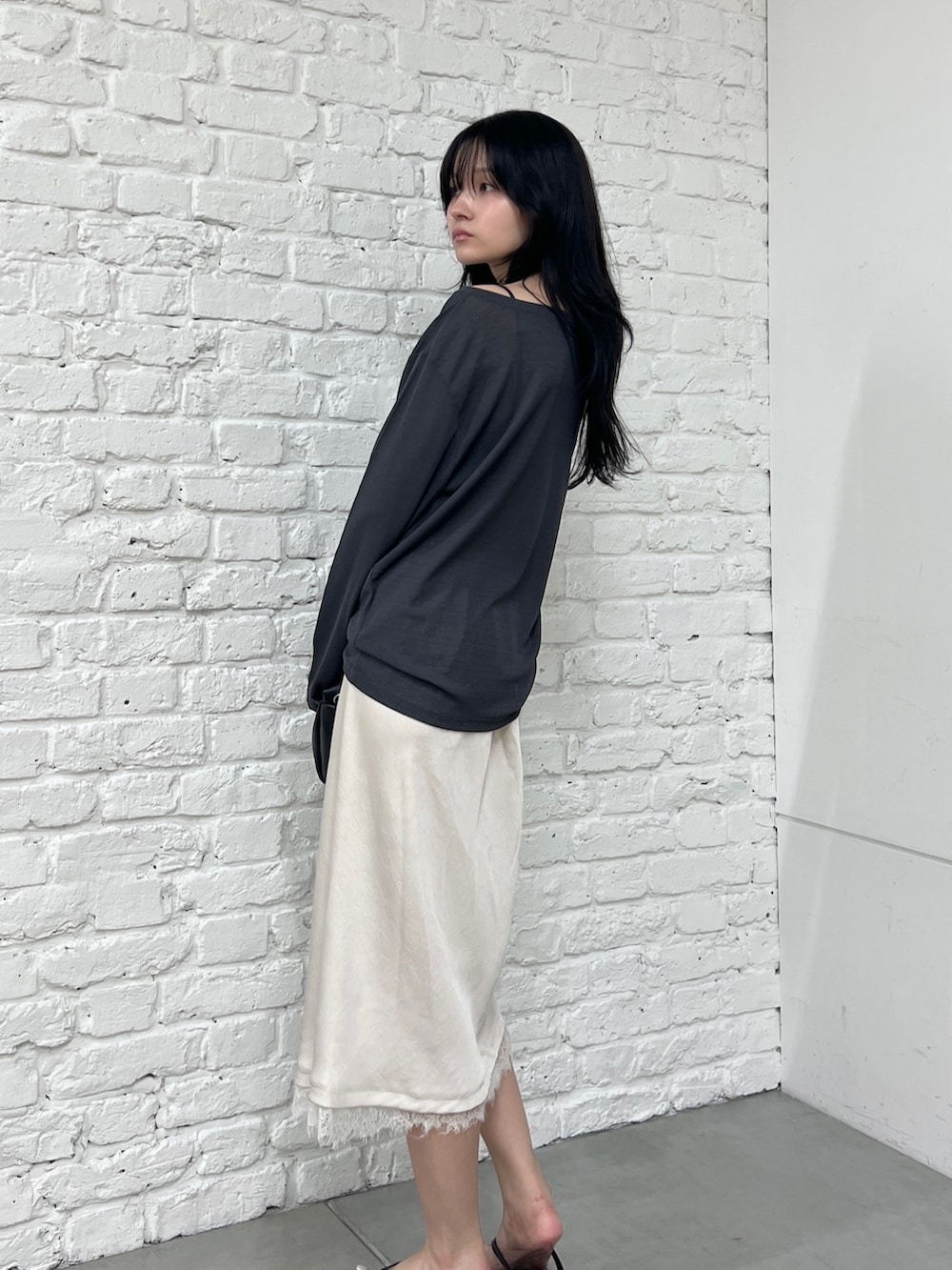 グレー系のTシャツ/カットソー、ホワイト系のスカート、ブラック系のショルダーバッグを着用したレディースの夏コーディネートの3枚目の写真