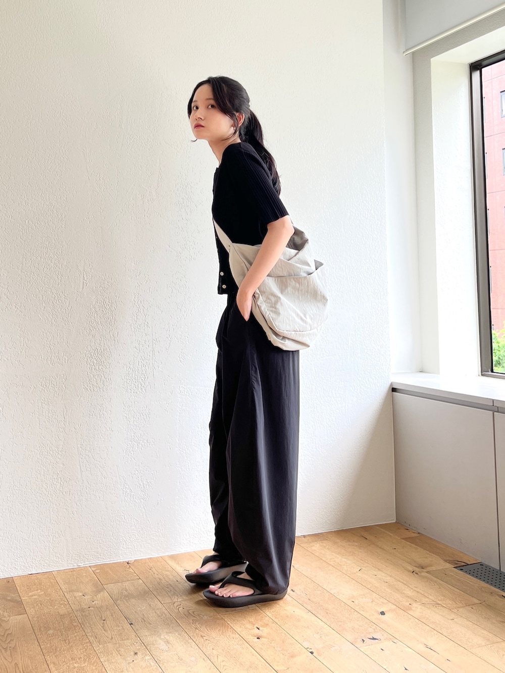 ブラック系のその他パンツ、ブラック系のカーディガン/ボレロ、グレー系のショルダーバッグを着用したレディースの夏コーディネートの2枚目の写真