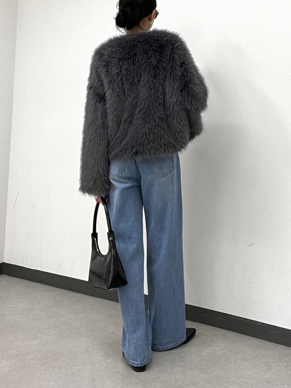 ブルー系のデニムパンツ、グレー系のその他アウター、ブラック系のトートバッグを着用したレディースの秋コーディネートの4枚目の写真