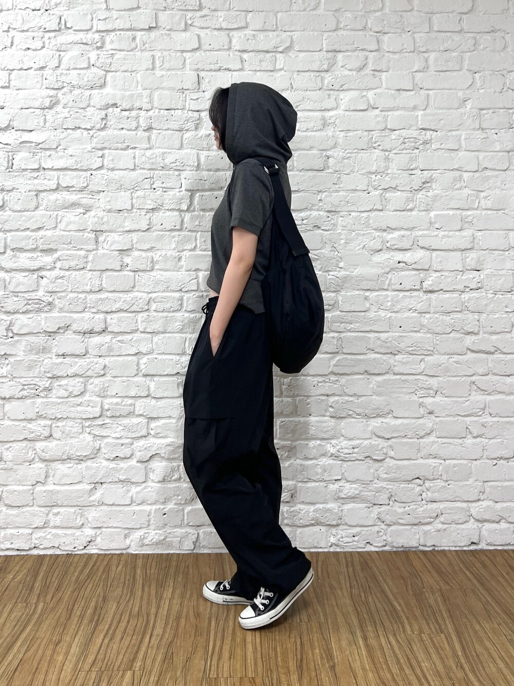 ブラック系のカーゴパンツ、ブラック系のTシャツ/カットソー、ブラック系のショルダーバッグを着用したレディースの夏コーディネートの2枚目の写真