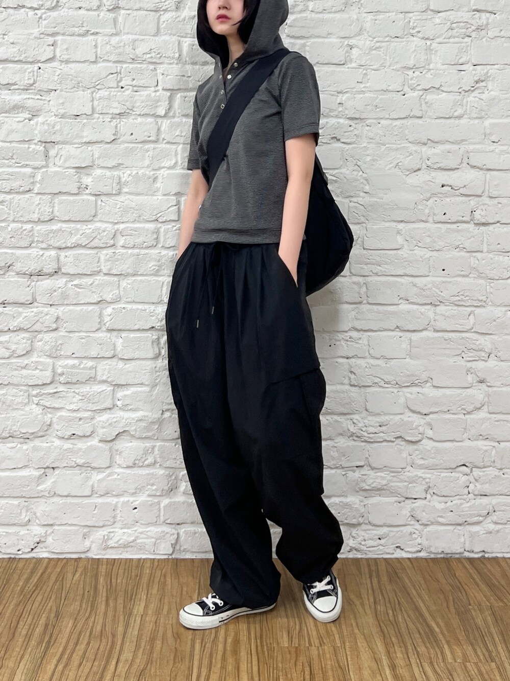 ブラック系のカーゴパンツ、ブラック系のTシャツ/カットソー、ブラック系のショルダーバッグを着用したレディースの夏コーディネートの4枚目の写真