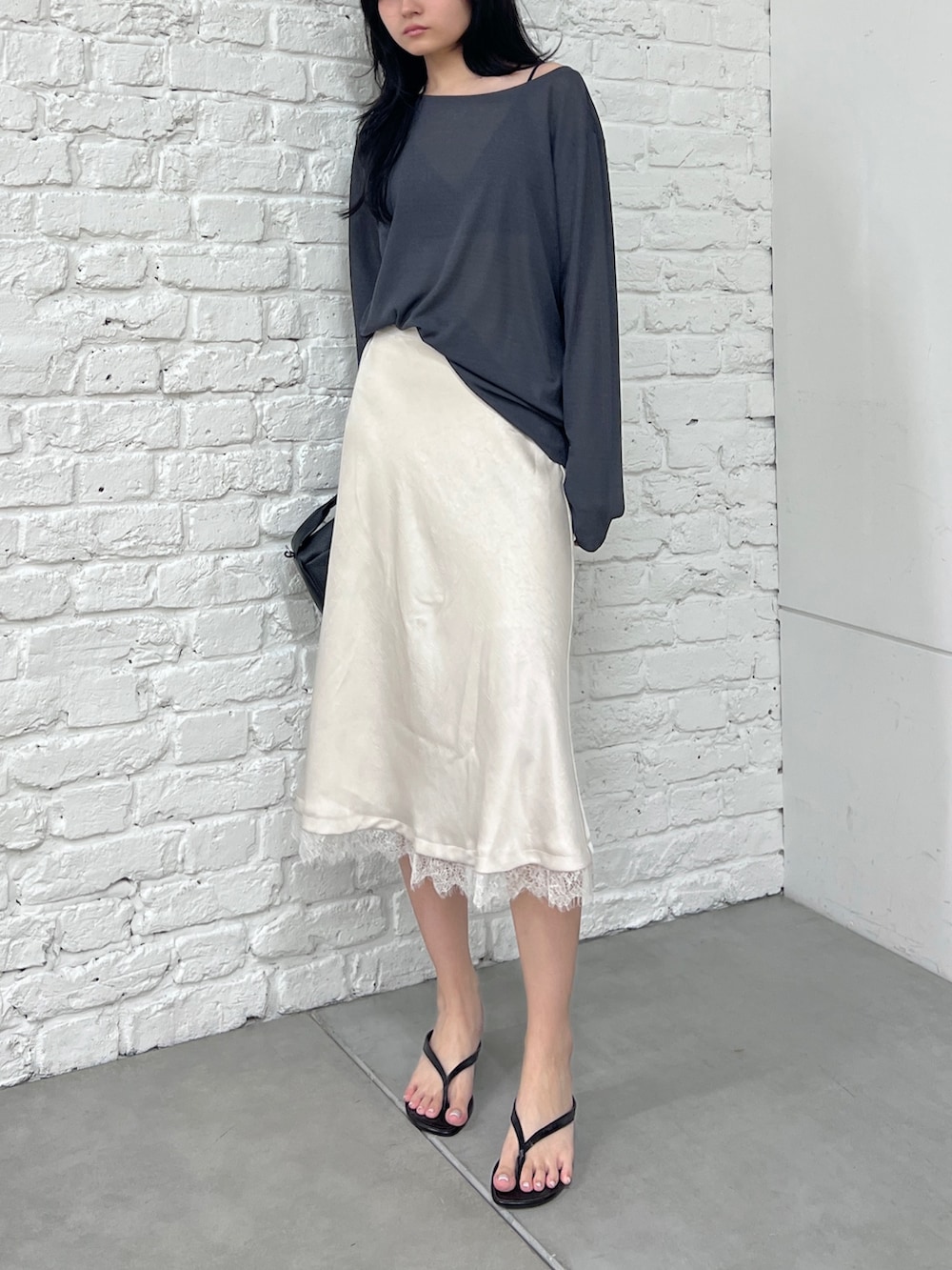グレー系のTシャツ/カットソー、ホワイト系のスカート、ブラック系のショルダーバッグを着用したレディースの夏コーディネートの2枚目の写真