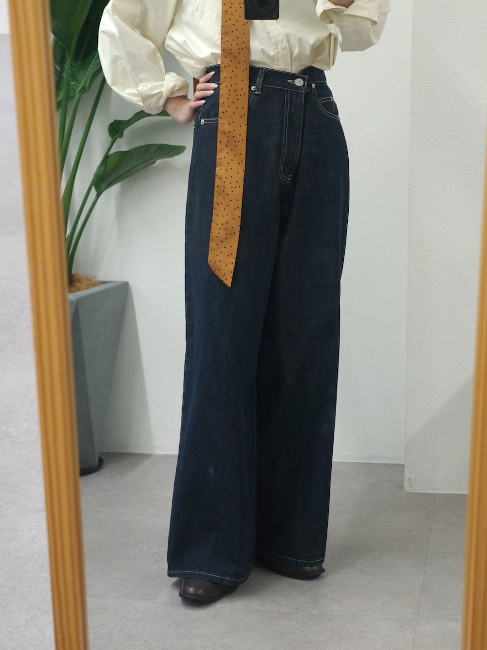 ブルー系のデニムパンツ、ブラウン系のブーツ、ホワイト系のシャツ/ブラウスを着用したレディースの夏コーディネートの3枚目の写真