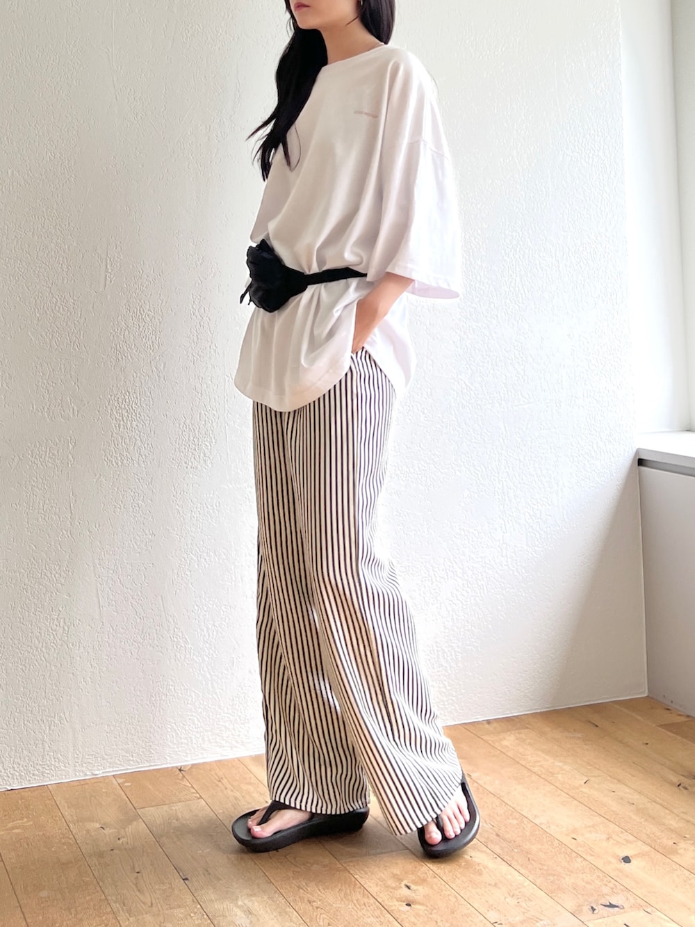 ホワイト系のTシャツ/カットソー、ブラック系のボディバッグ/ウエストポーチ、ブルー系のその他パンツを着用したレディースの夏コーディネートの3枚目の写真