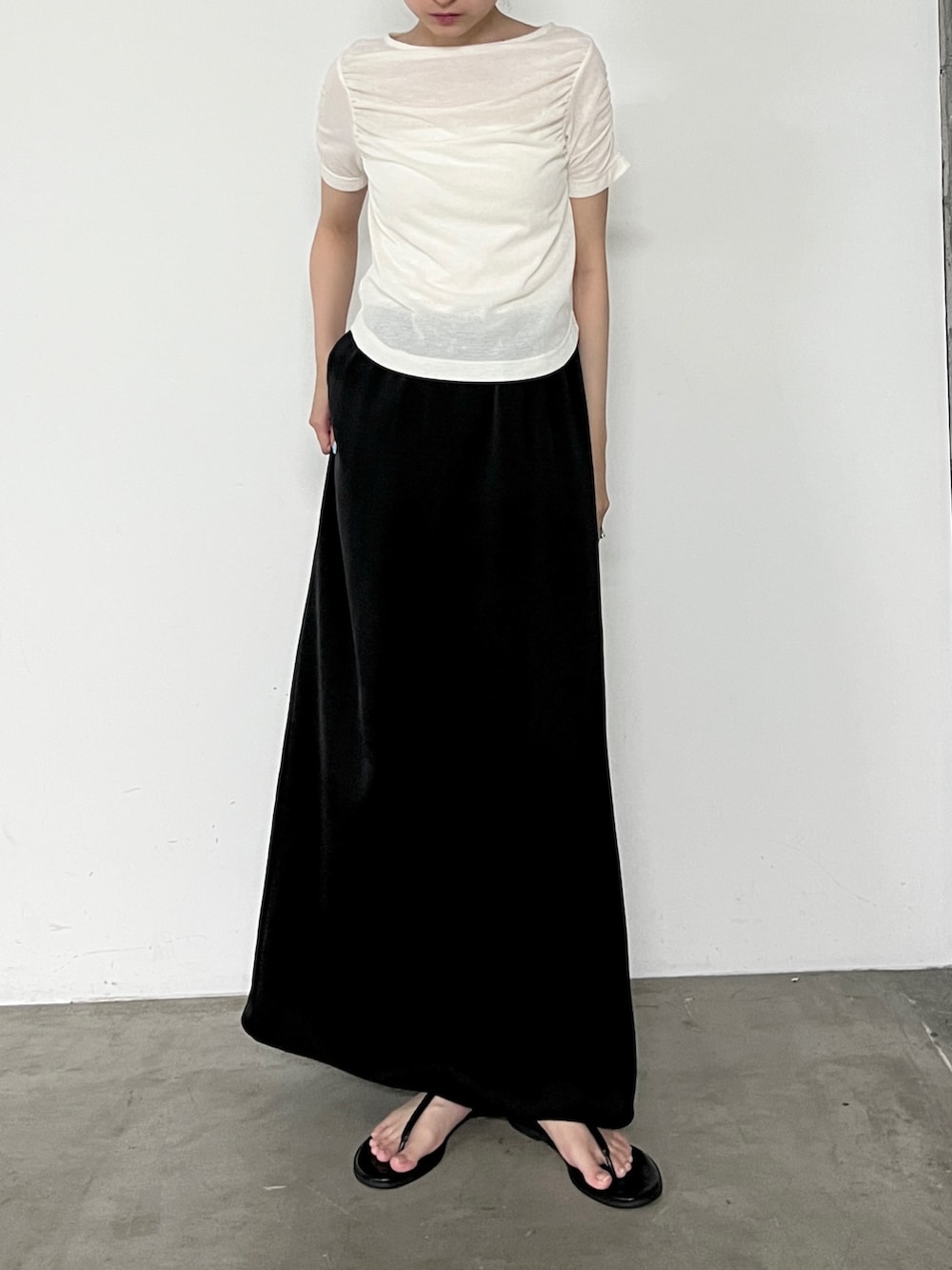 ホワイト系のTシャツ/カットソー、ブラック系のスカート、ブラック系のサンダルを着用したレディースの夏コーディネートの4枚目の写真