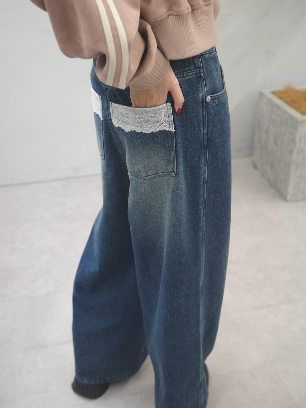 ブルー系のデニムパンツ、ピンク系のブルゾン、ブラック系のショルダーバッグを着用したレディースの秋コーディネートの4枚目の写真