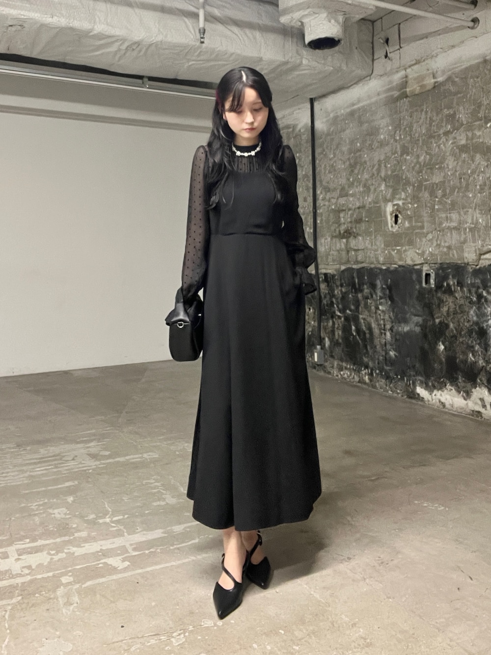 ブラック系のショルダーバッグ、ブラック系のワンピース、ブラック系のパンプスを着用したレディースの秋コーディネートの2枚目の写真