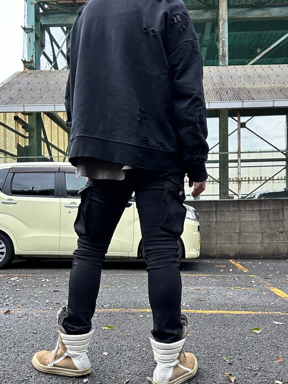 ベージュ系のスニーカー、ブラック系のカーゴパンツ、ブラック系のスウェットを着用したメンズの春コーディネートの2枚目の写真