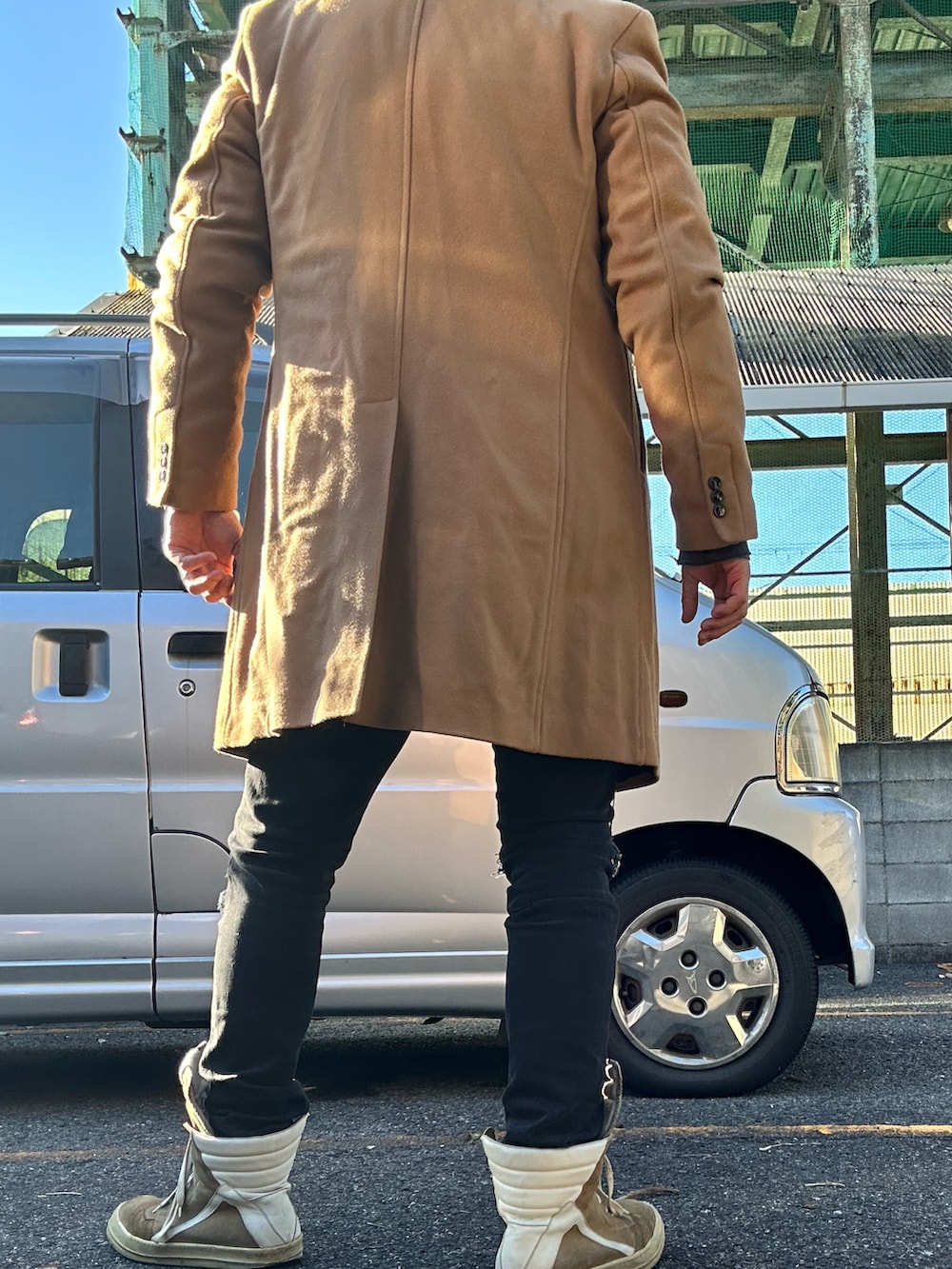 ベージュ系のスニーカー、ブラック系のデニムパンツ、グレー系のパーカーを着用したメンズの冬コーディネートの2枚目の写真