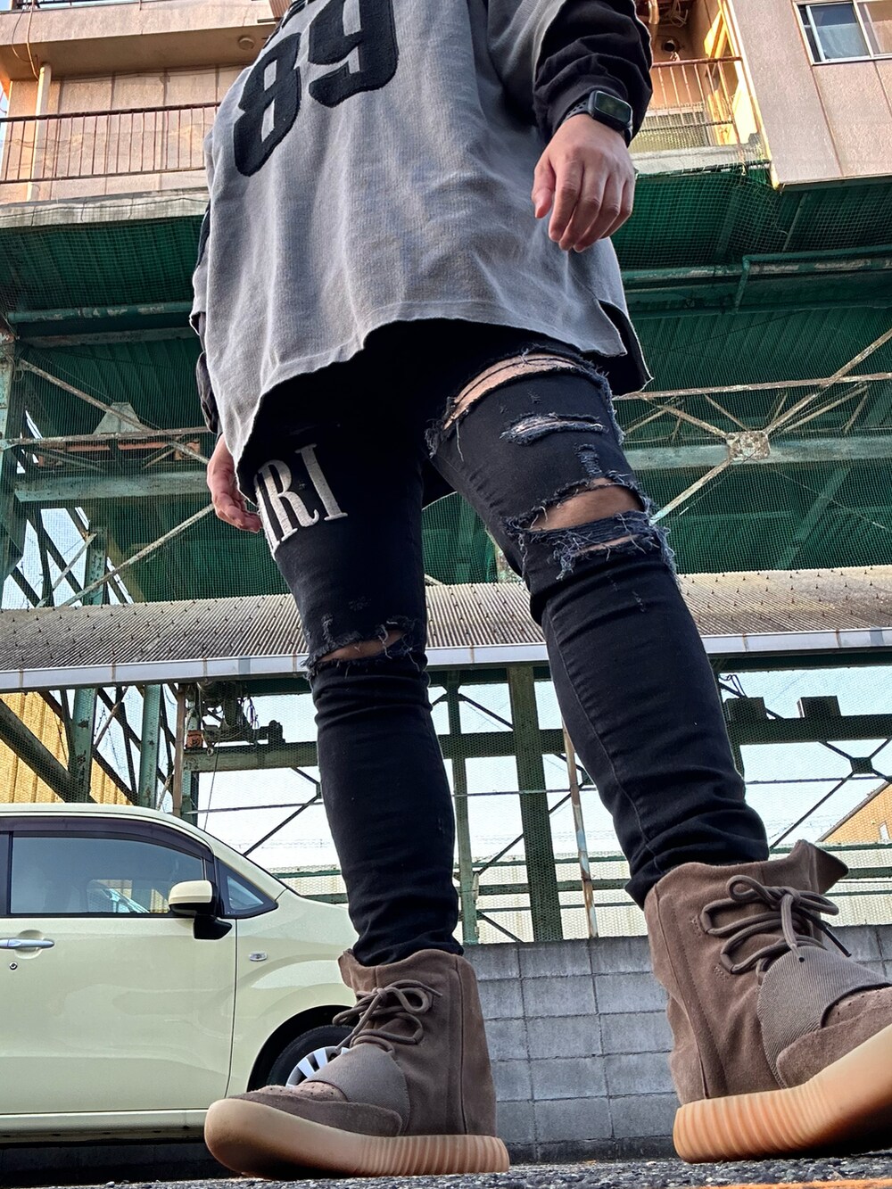 グレー系のニット/セーター、ブラック系のTシャツ/カットソー、ブラック系のデニムパンツを着用したメンズの秋コーディネートの2枚目の写真