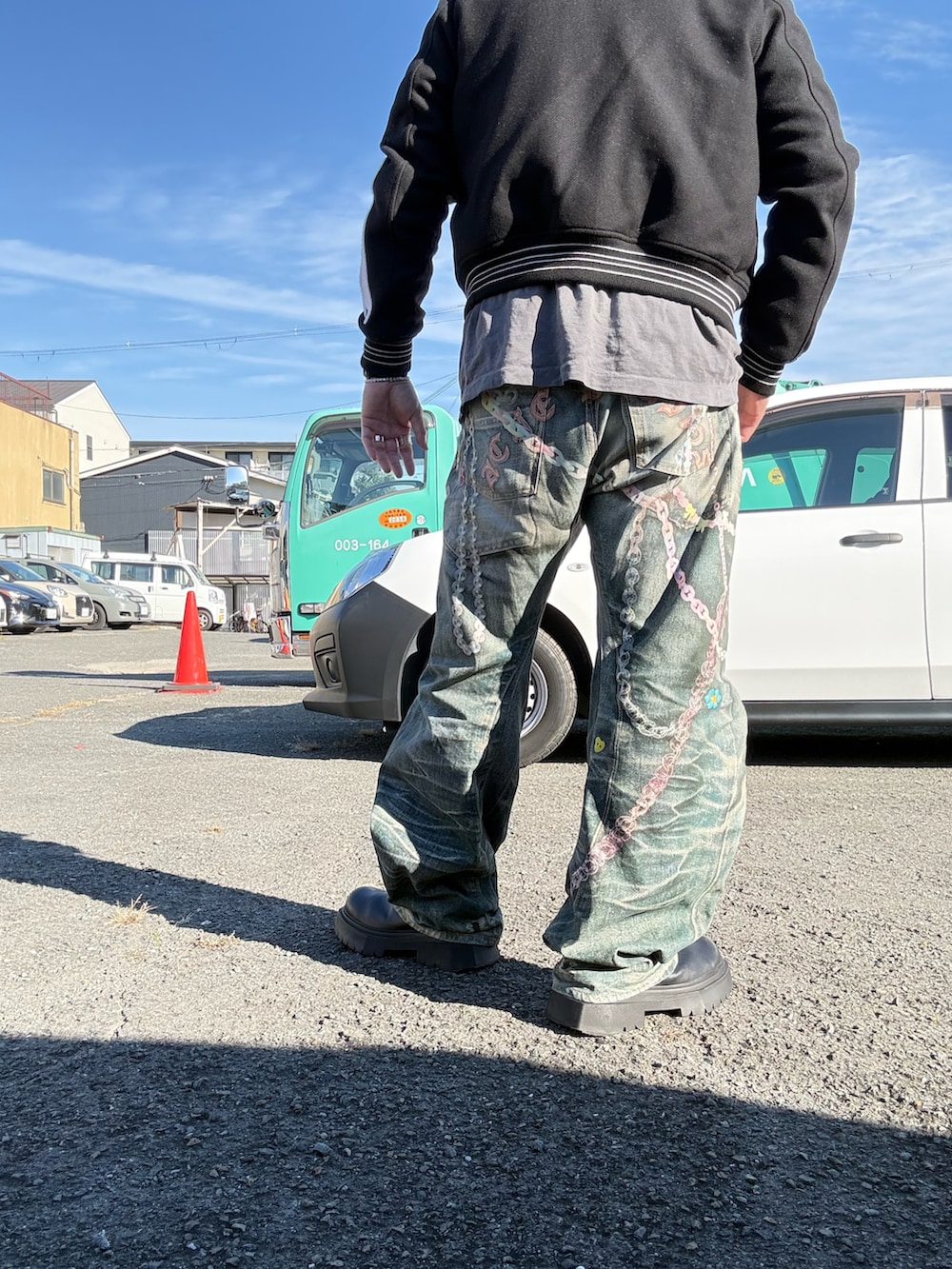 グレー系のデニムパンツ、ブラック系のブルゾン、グレー系のTシャツ/カットソーを着用したメンズの秋コーディネートの2枚目の写真