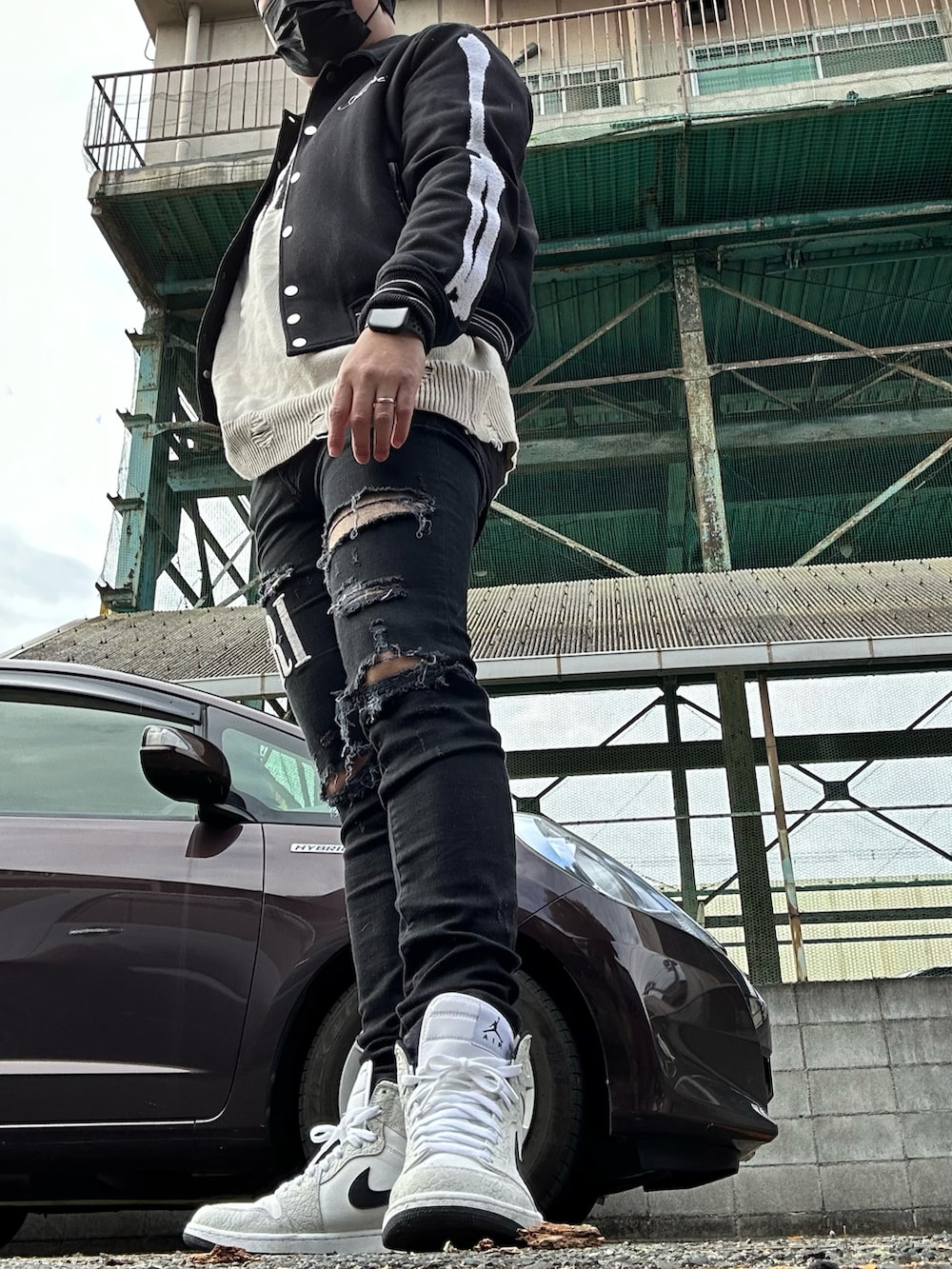 ホワイト系のスニーカー、ブラック系のデニムパンツ、ブラック系のブルゾンを着用したメンズの冬コーディネートの2枚目の写真