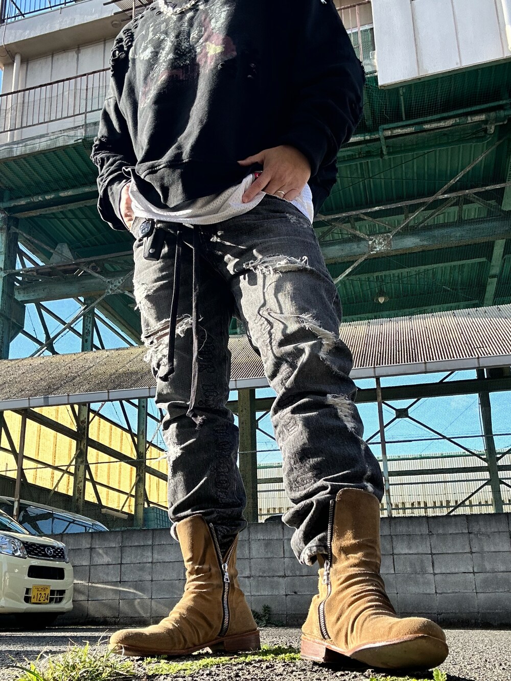 ベージュ系のブーツ、ブラック系のデニムパンツ、ブラック系のスウェットを着用したメンズの春コーディネートの2枚目の写真