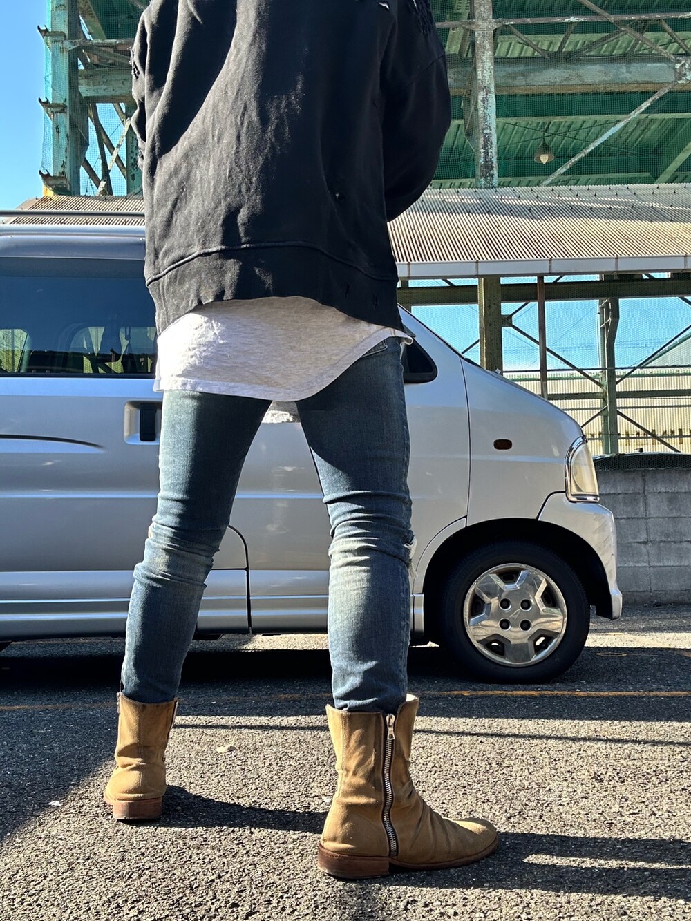 ベージュ系のブーツ、ブルー系のデニムパンツ、ブラック系のスウェットを着用したメンズの秋コーディネートの2枚目の写真