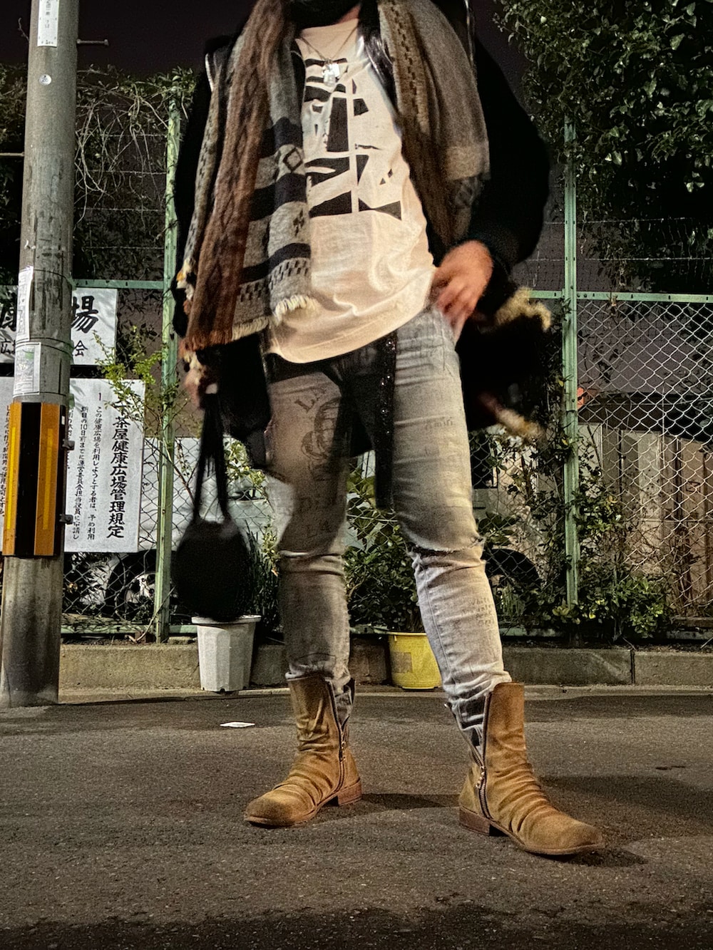 ベージュ系のブーツ、ブルー系のデニムパンツ、グレー系のボストンバッグを着用したメンズの冬コーディネートの2枚目の写真