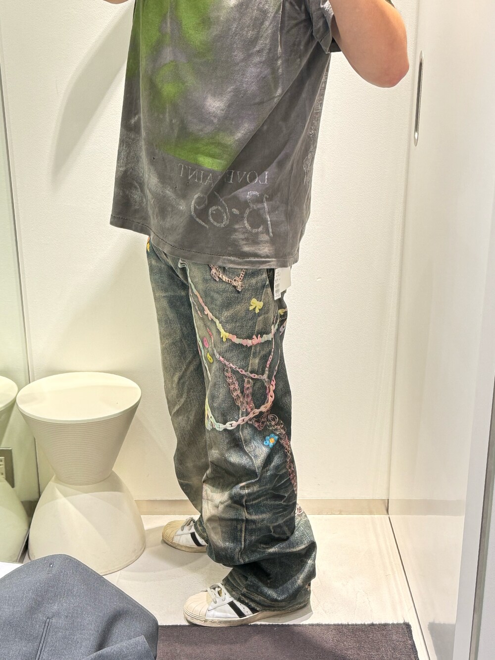 グレー系のデニムパンツ、グレー系のTシャツ/カットソー、ホワイト系のスニーカーを着用したメンズの春コーディネートの2枚目の写真