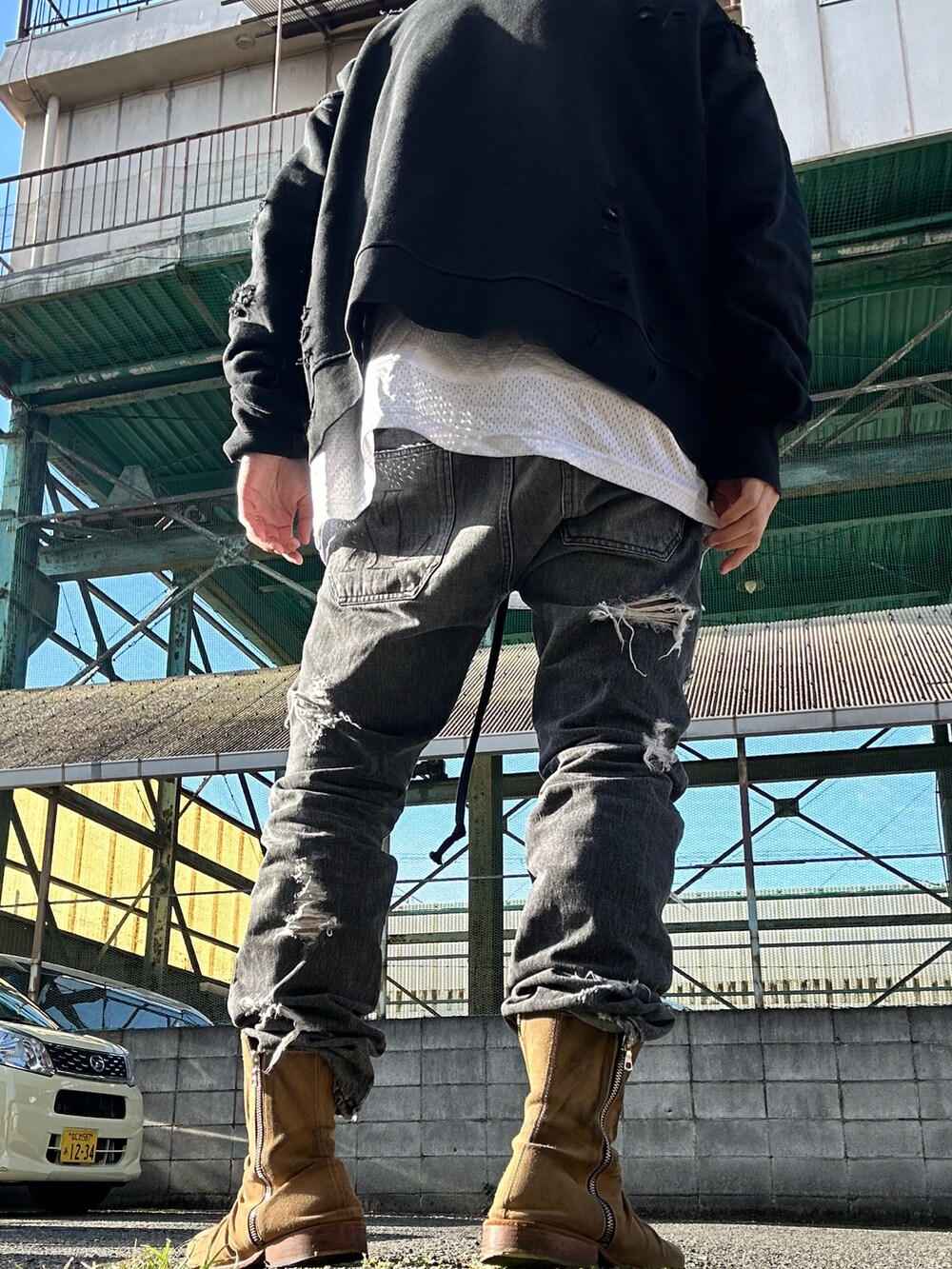 ベージュ系のブーツ、ブラック系のデニムパンツ、ブラック系のスウェットを着用したメンズの春コーディネートの3枚目の写真