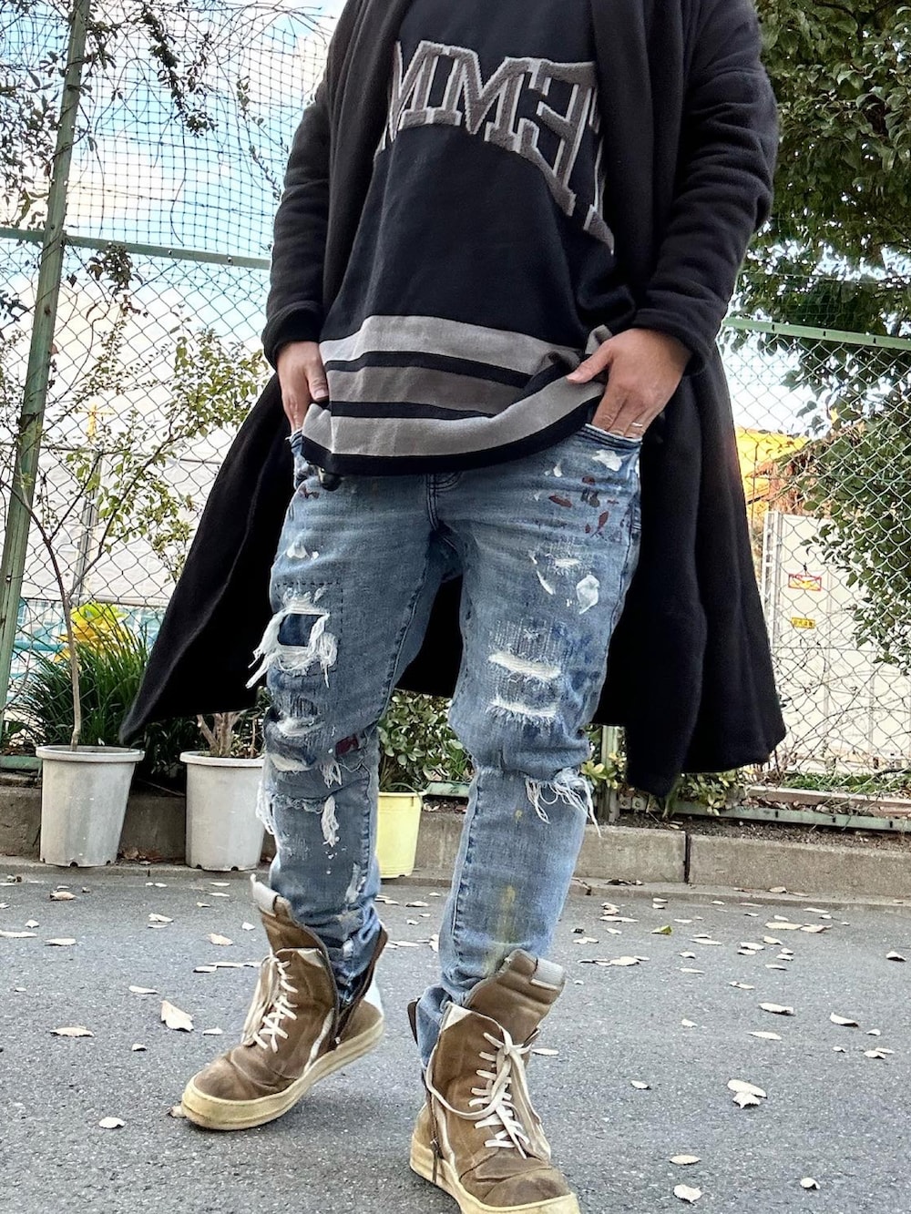 ブラック系のニット/セーター、ベージュ系のスニーカー、ブルー系のデニムパンツを着用したメンズの冬コーディネートの2枚目の写真