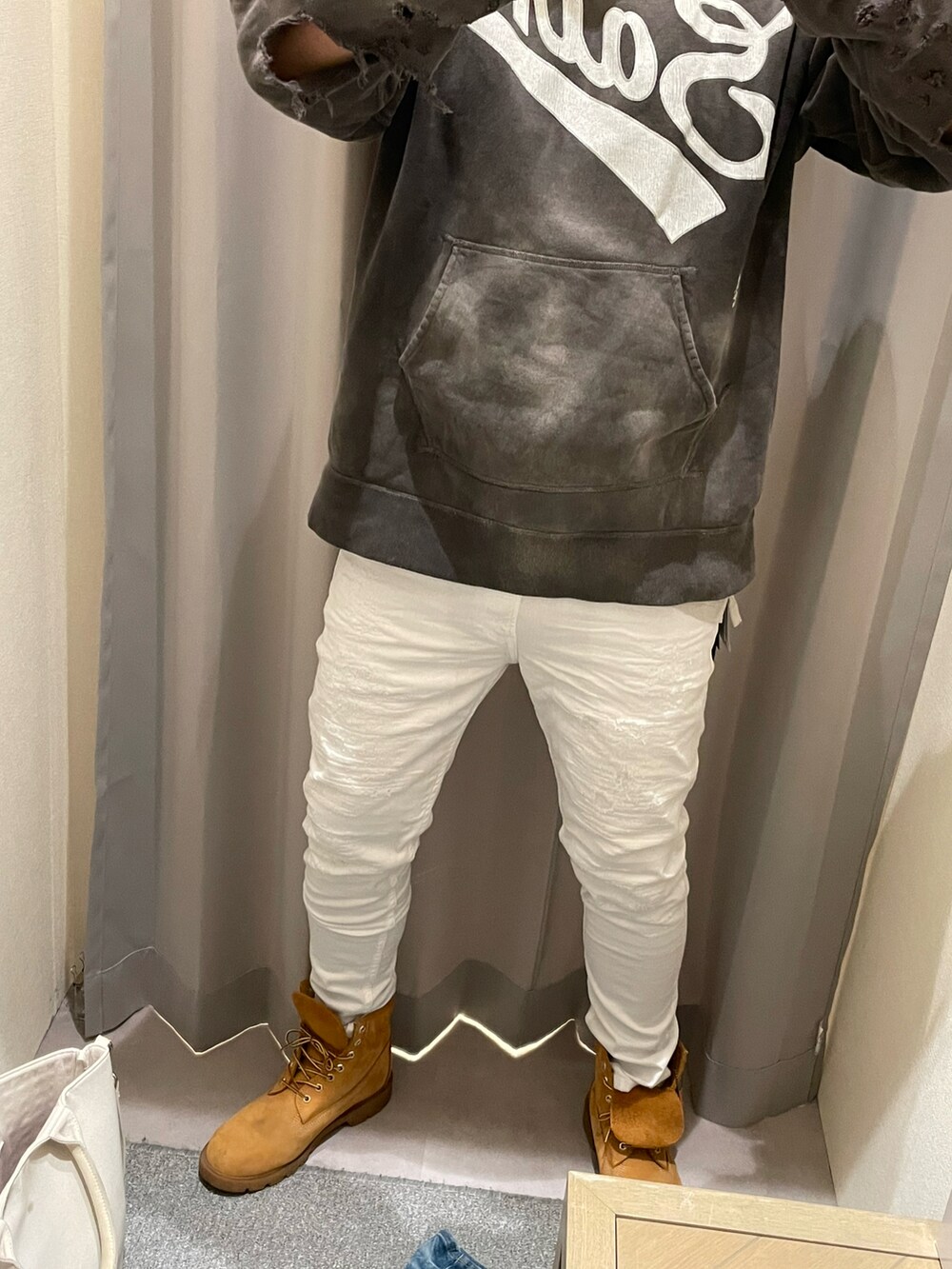 ベージュ系のブーツ、ブルー系のデニムパンツ、グレー系のパーカーを着用したメンズの春コーディネートの2枚目の写真