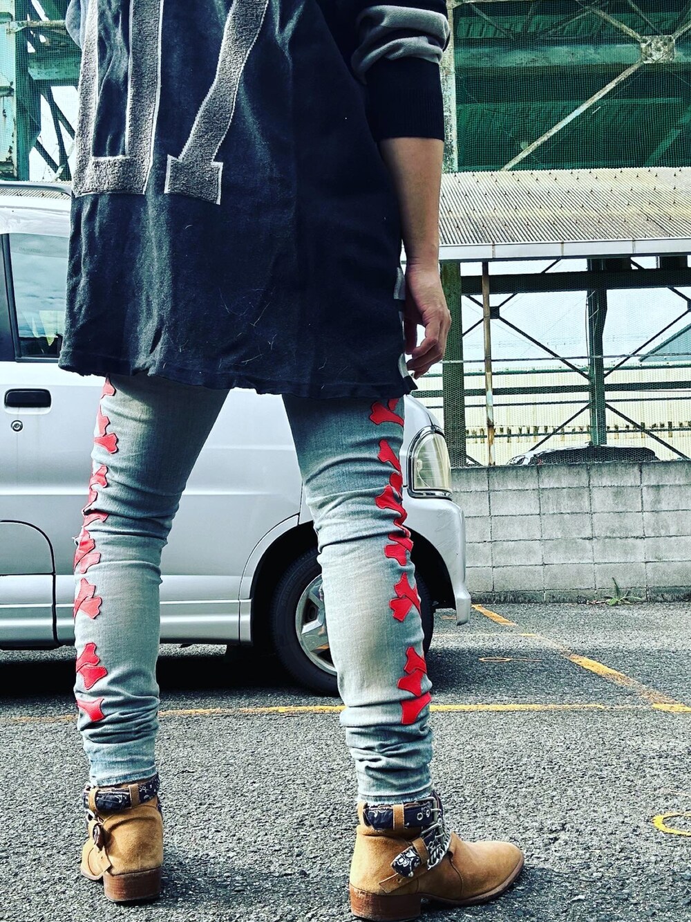 ベージュ系のブーツ、ブルー系のデニムパンツ、ブラック系のニット/セーターを着用したメンズの秋コーディネートの2枚目の写真