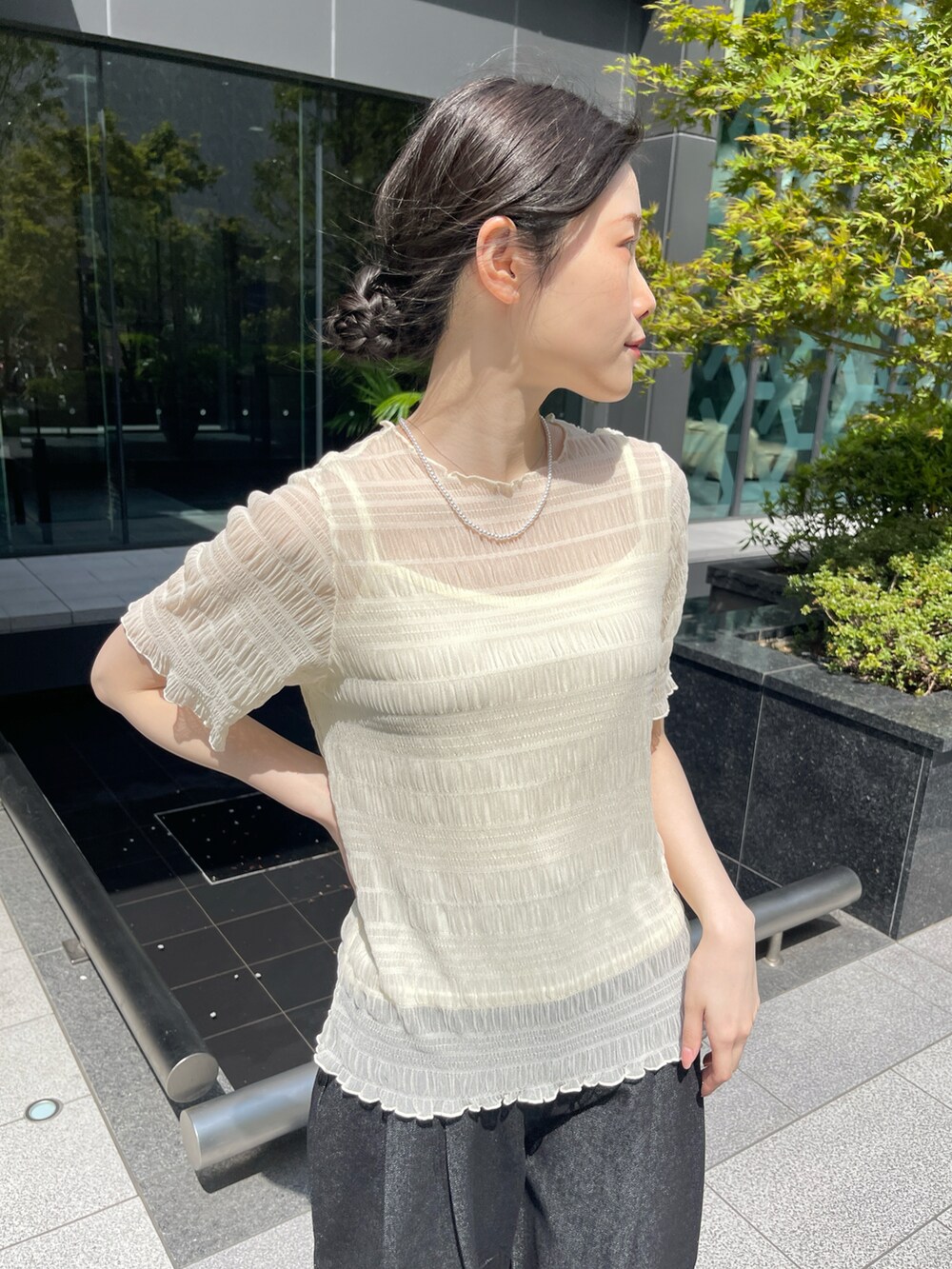 ベージュ系のTシャツ/カットソー、ブラック系のデニムパンツを着用したレディースの春コーディネートの2枚目の写真