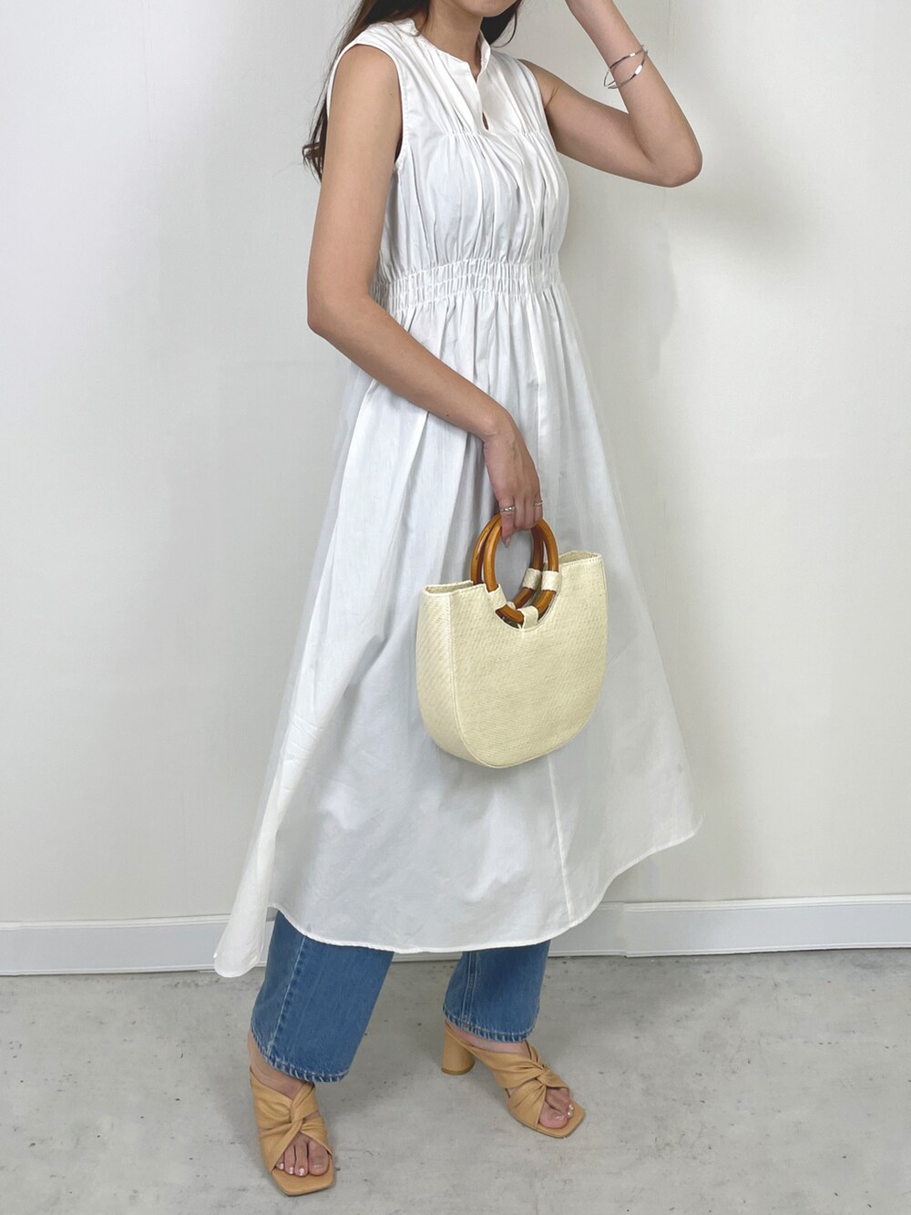 ホワイト系のバッグ、ホワイト系のワンピース、その他のスカートを着用したレディースの春コーディネートの2枚目の写真