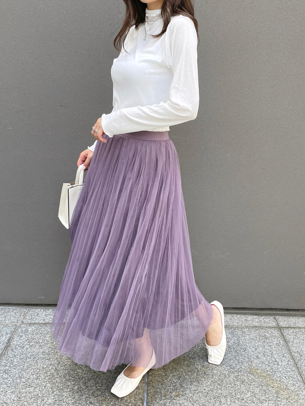 ホワイト系のTシャツ/カットソー、パープル系のスカート、ホワイト系のパンプスを着用したレディースの夏コーディネートの2枚目の写真