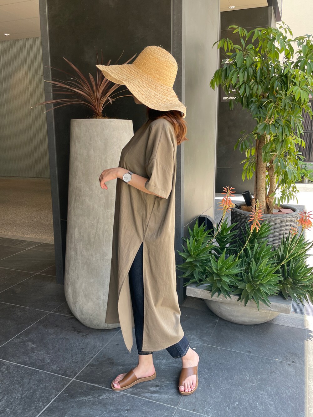 ブラウン系のワンピース、イエロー系のサンダル、ブルー系のデニムパンツを着用したレディースの夏コーディネートの3枚目の写真