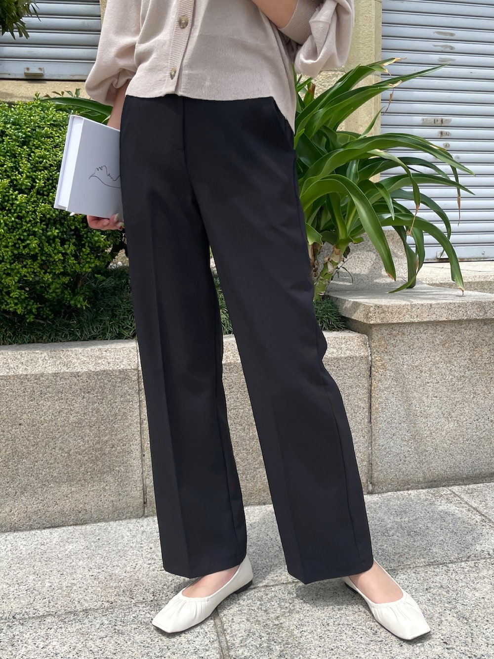 ベージュ系のカーディガン/ボレロ、ブラック系のスラックス、ホワイト系のパンプスを着用したレディースの春コーディネートの2枚目の写真