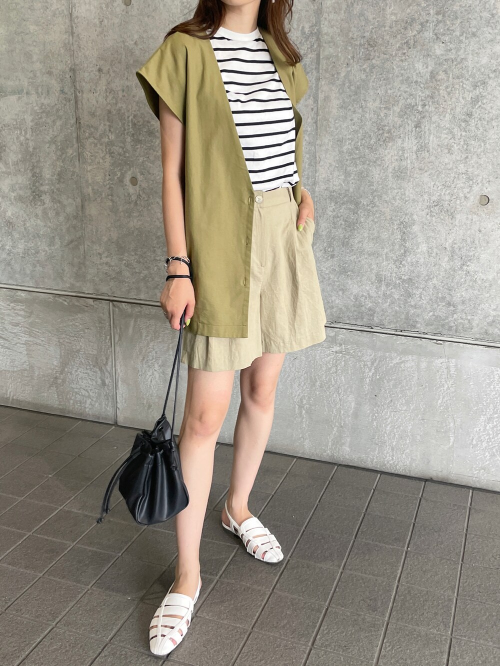 グリーン系のベスト、グリーン系のその他パンツ、ブラック系のショルダーバッグを着用したレディースの夏コーディネートの3枚目の写真