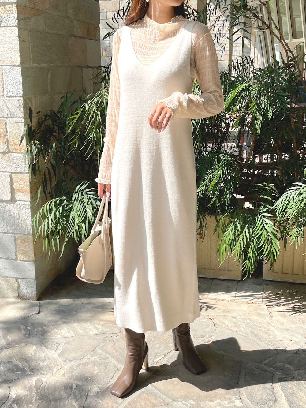 ホワイト系のワンピース、ホワイト系のTシャツ/カットソー、ブラウン系のブーツを着用したレディースの秋コーディネートの2枚目の写真