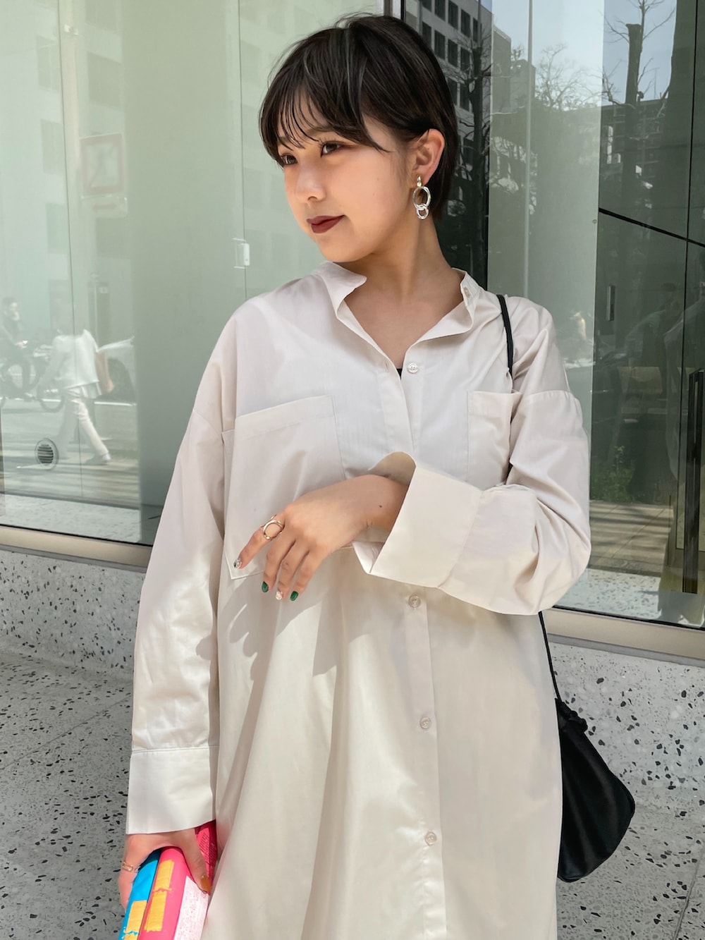 ベージュ系のシャツワンピース、イエロー系のスラックス、ホワイト系のパンプスを着用したレディースの春コーディネートの2枚目の写真