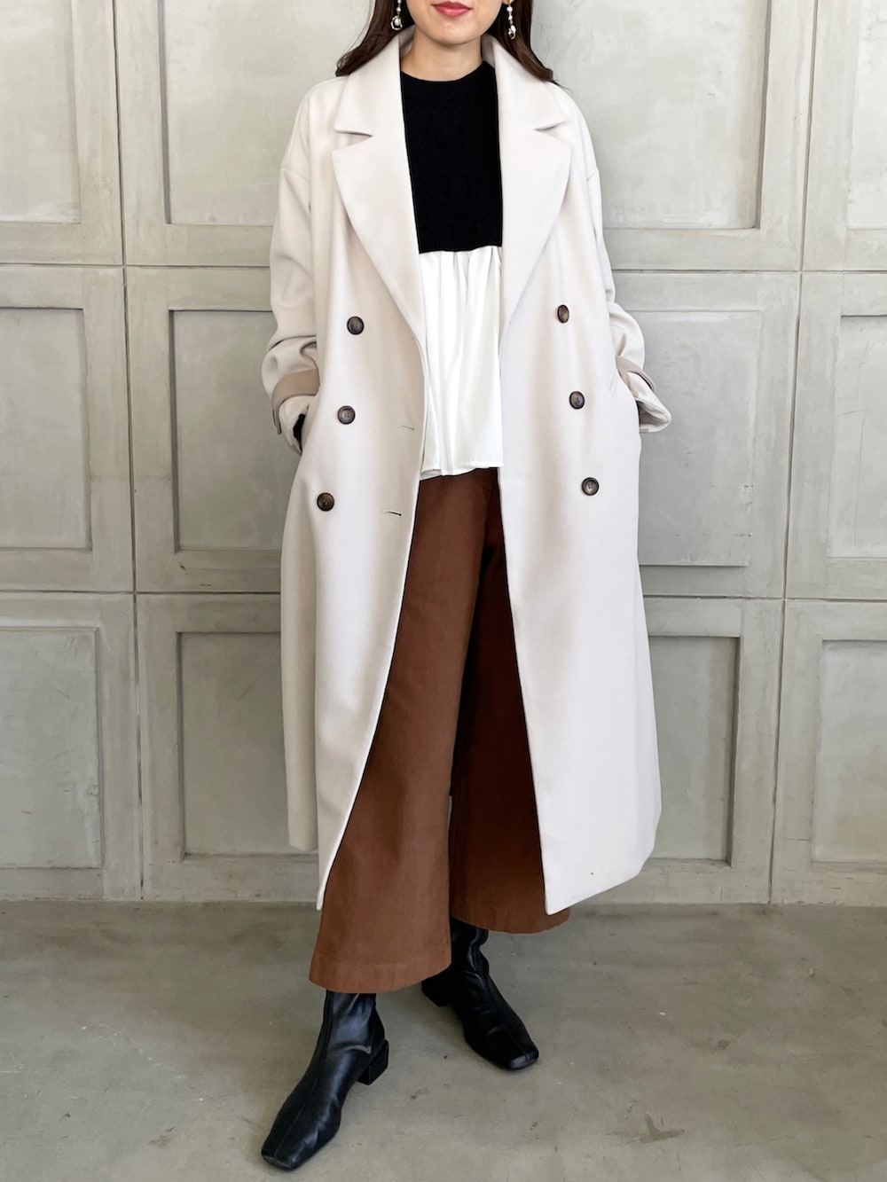 ホワイト系のトレンチコートを着用したレディースの秋コーディネートの2枚目の写真