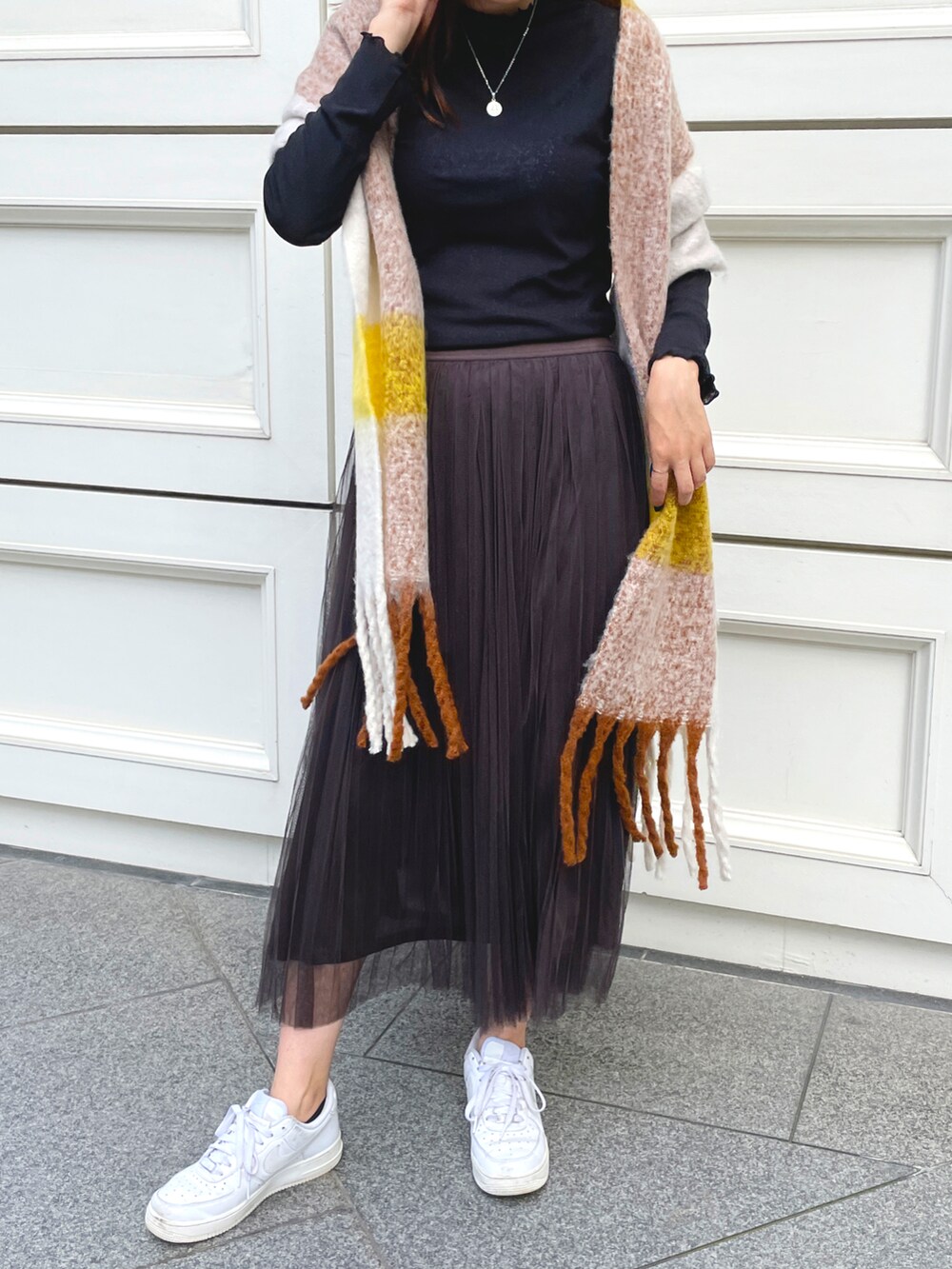 ブラック系のTシャツ/カットソー、グレー系のスカート、ホワイト系のスニーカーを着用したレディースの夏コーディネートの2枚目の写真