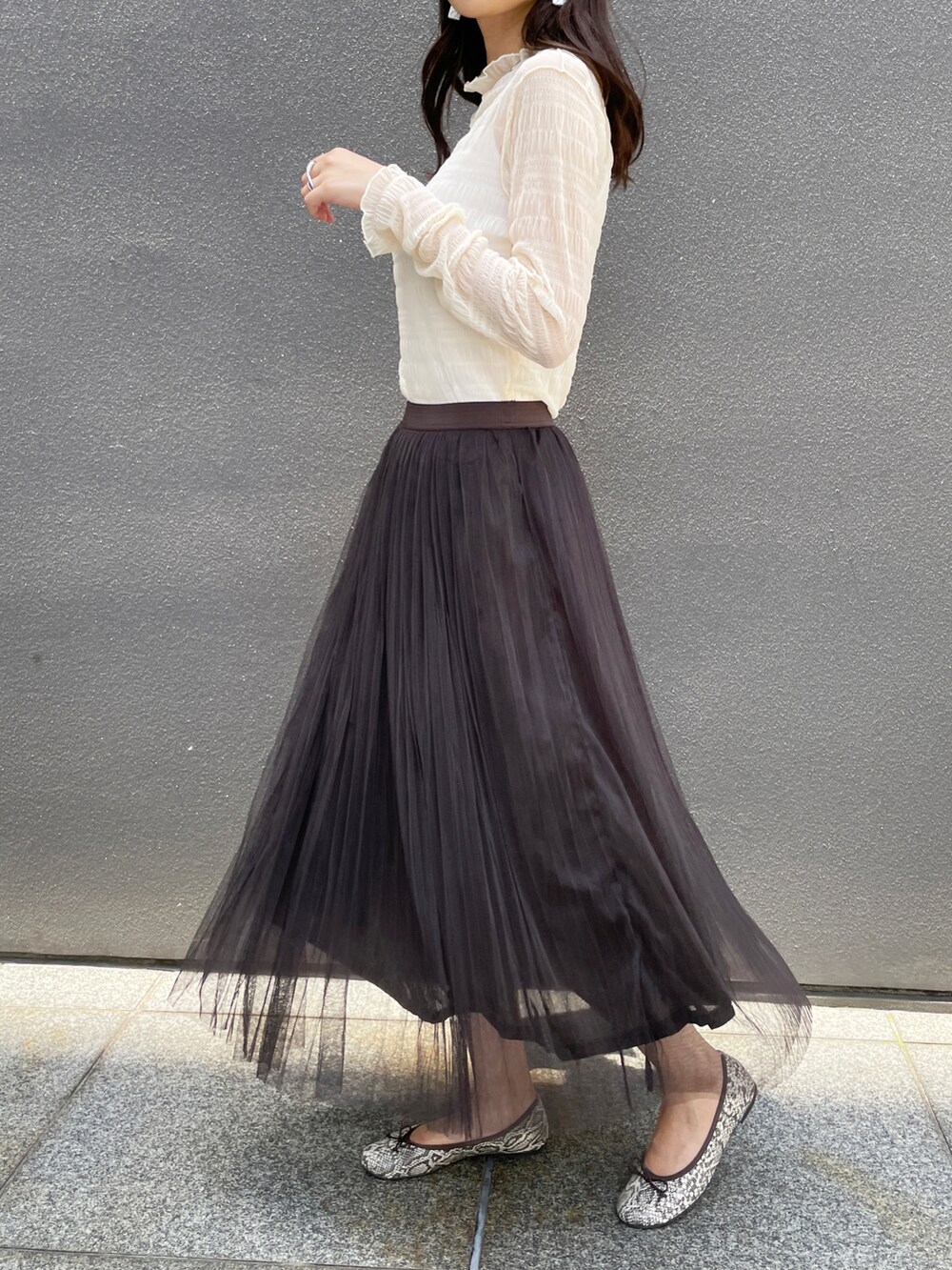 グレー系のスカート、ホワイト系のTシャツ/カットソーを着用したレディースの夏コーディネートの2枚目の写真