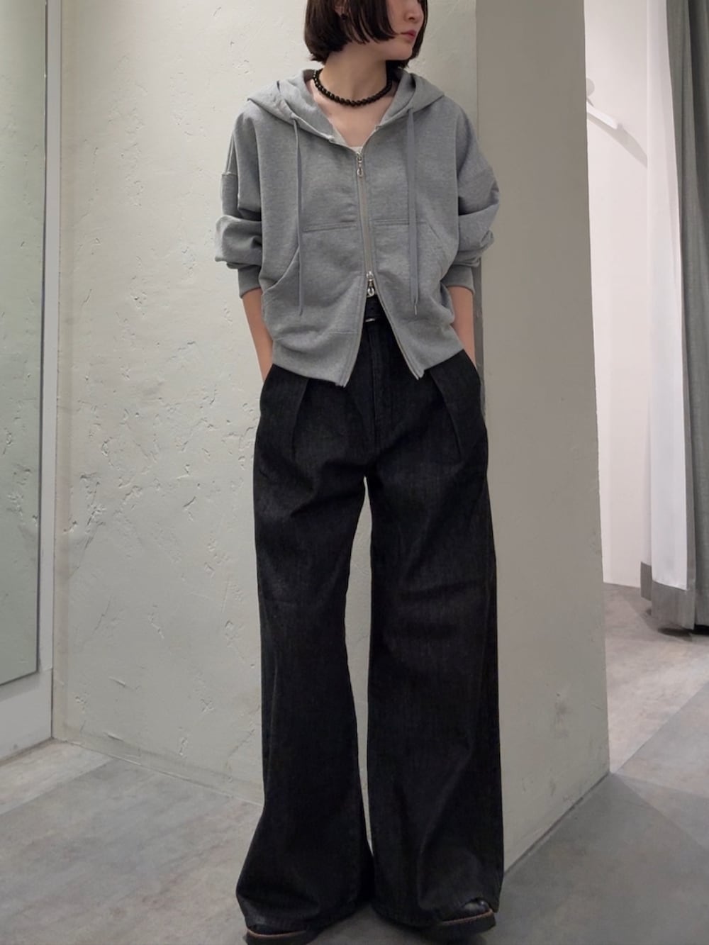 グレー系のパーカー、ブラック系のデニムパンツを着用したレディースの秋コーディネートの2枚目の写真