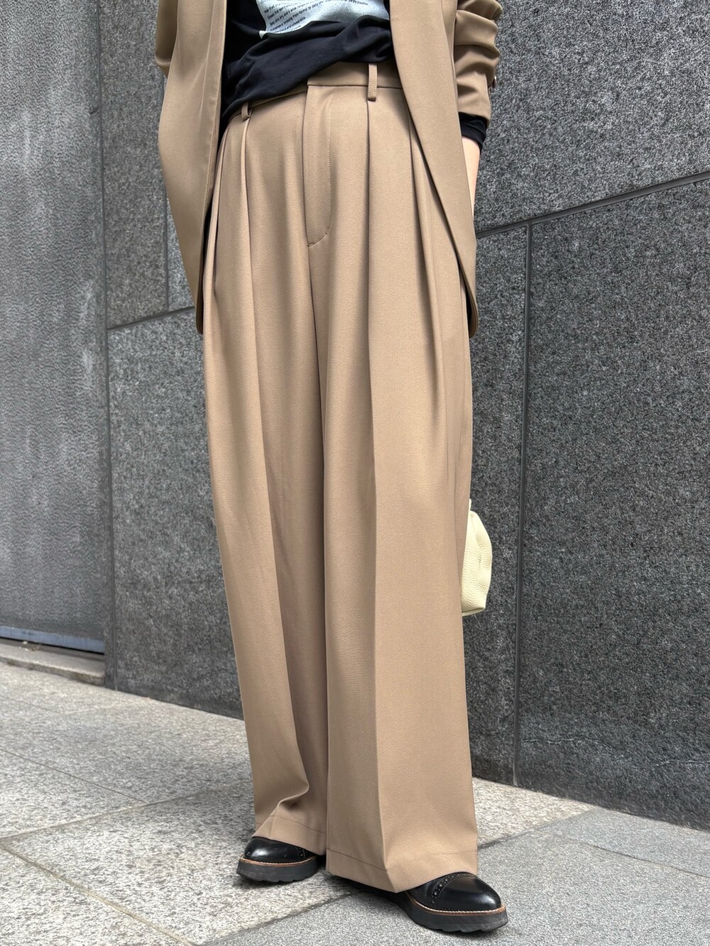 ブラウン系のスラックス、ブラウン系のショルダーバッグ、ブラック系のTシャツ/カットソーを着用したレディースの秋コーディネートの4枚目の写真