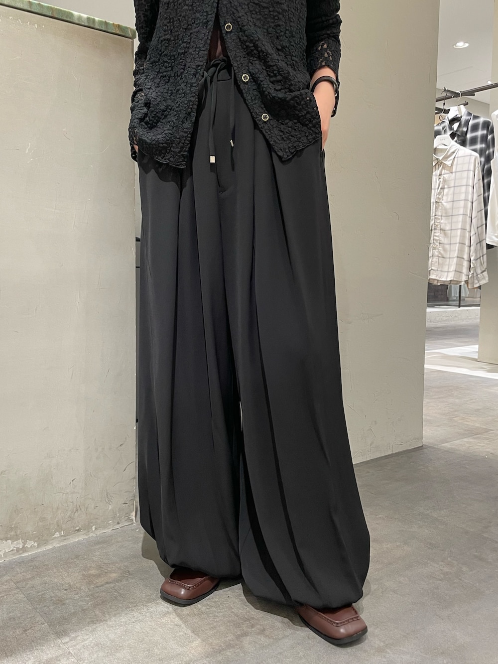 ブラック系のシャツ/ブラウス、ブラック系のその他パンツ、ブラウン系のローファーを着用したレディースの秋コーディネートの4枚目の写真