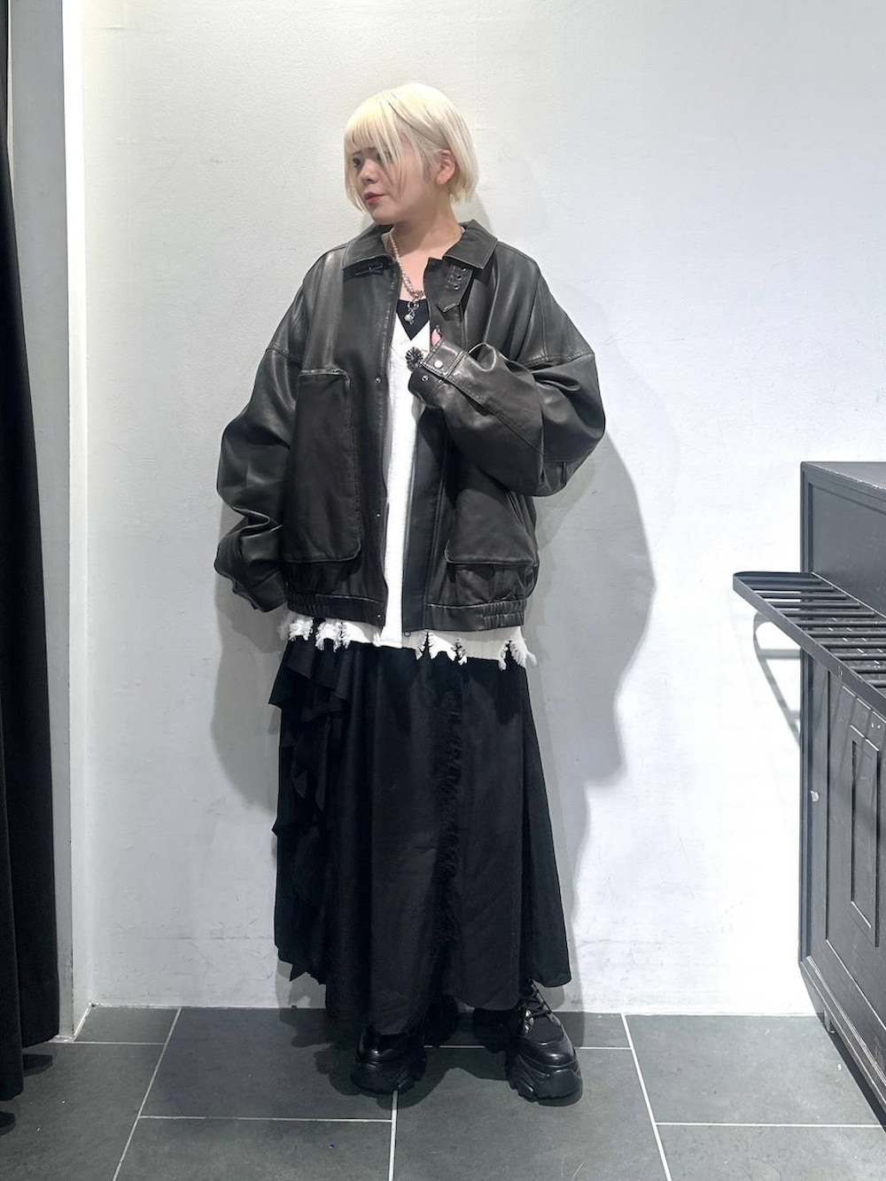 ブラック系のブーツ、ブラック系のブルゾン、ブラック系のスカートを着用したレディースの秋コーディネートの2枚目の写真