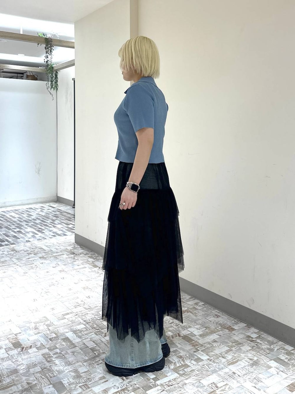 ブラック系のスニーカー、ブルー系のデニムパンツ、ブラック系のスカートを着用したレディースの春コーディネートの3枚目の写真